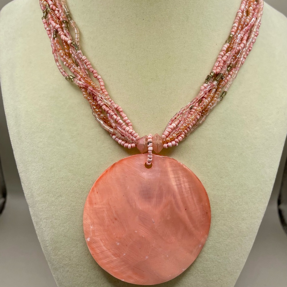 Faux pearl pink round shell pendant with a eight strand seed bead necklace